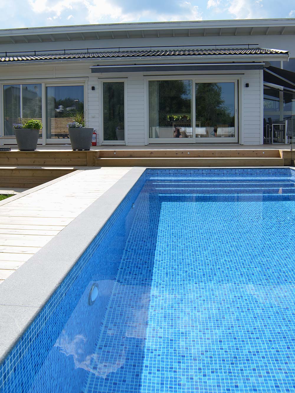 Blått skimrande vatten i poolen som sprider sig over trädgården - Pool inspiration från kund